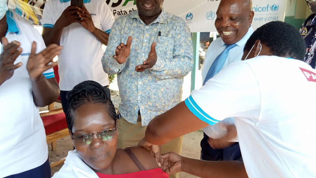 Joan Wasike, County Laboratory coordinator, Bungoma, western Kenya, receives her booster vaccine at the launch. Looking on are County Health Services Director Dr Johnstone Akatu and Health Executive Dr Anthony Walela.  Photo Credit: Gabriel Ingubu.